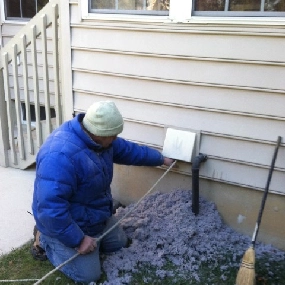 Technician cleaning dryer vent outside the house
