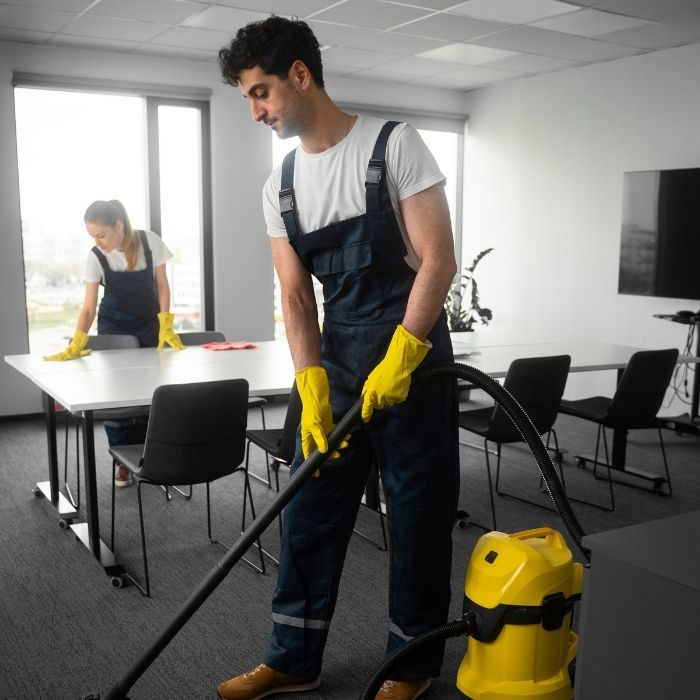 The workers are cleaning the carpet and the table.